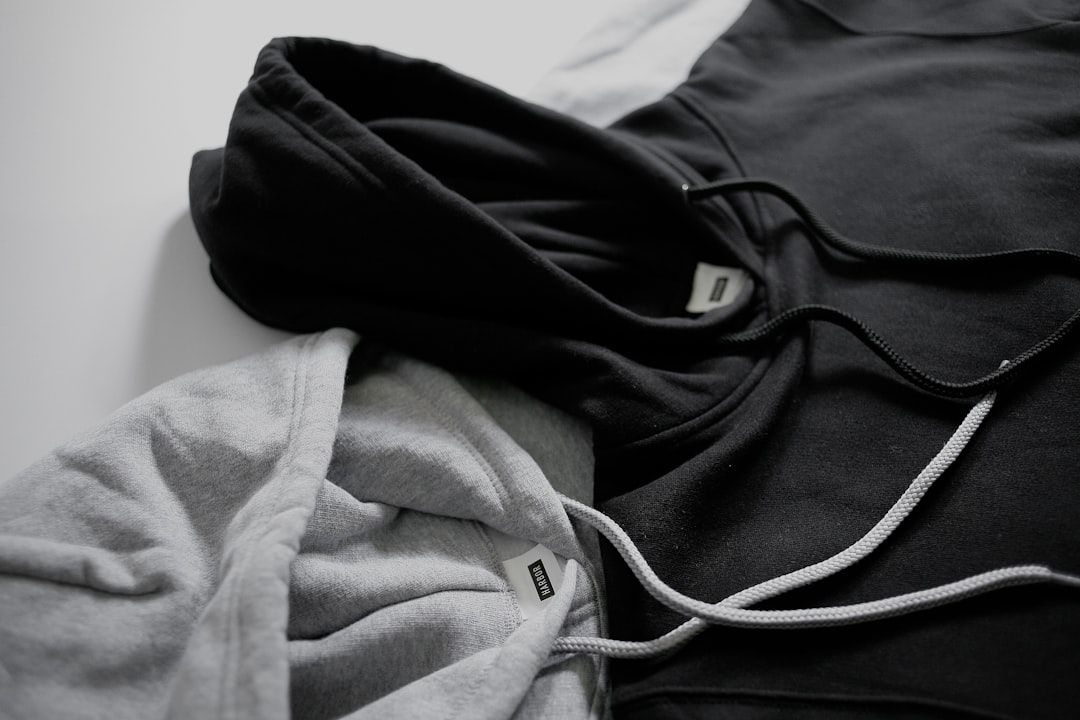 Närbild på en svart och en grå hoodie med dragskor